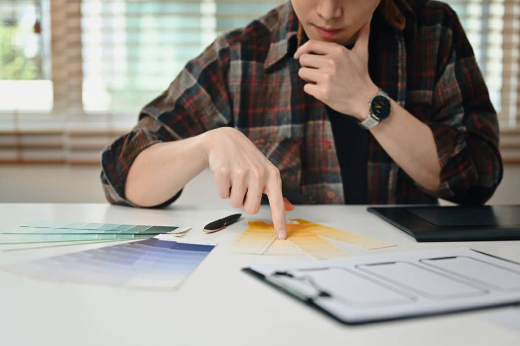 Focused male website developer planning application development for web mobile phone.