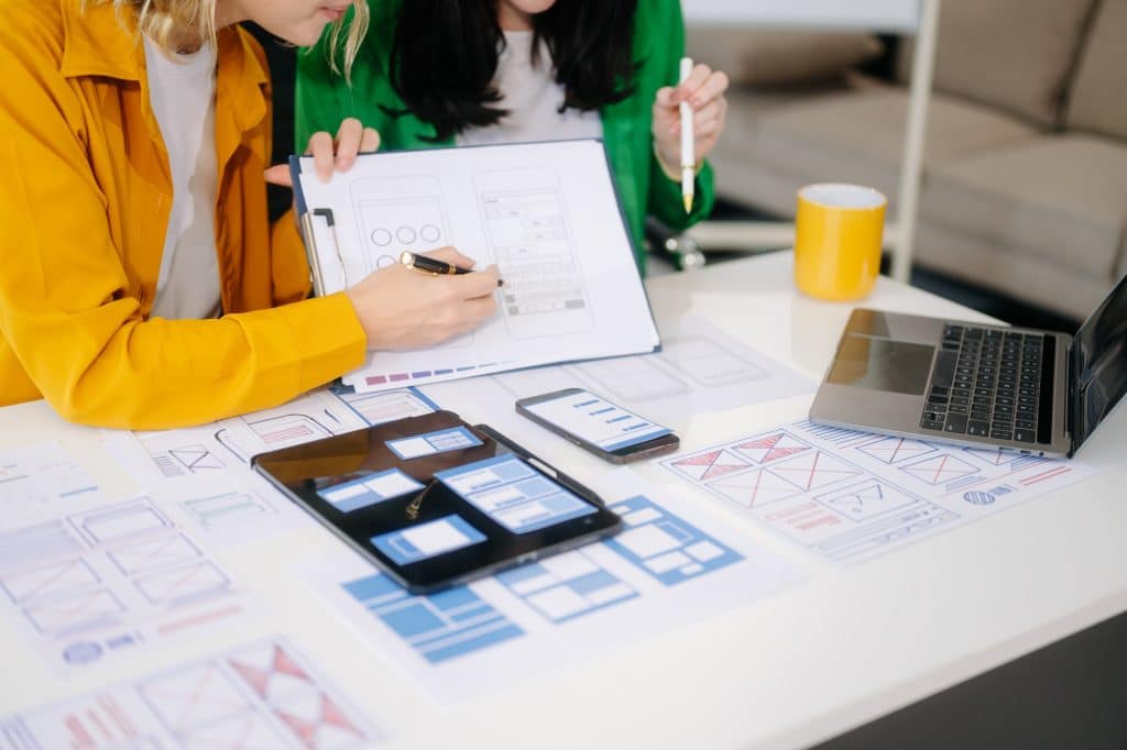 UX developer and ui designer brainstorming about mobile app interface wireframe design